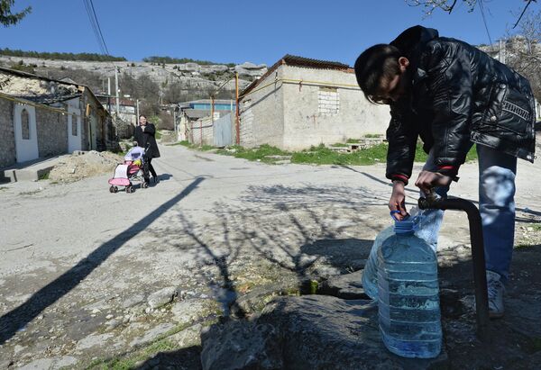 Мальчик набирает воду из колонки Мальчик набирает воду из колонки