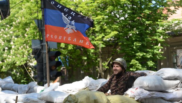 Активист сил самообороны сторонников федерализации Украины на баррикаде под флагом ДНР. Архивное фото Активист сил самообороны сторонников федерализации Украины на баррикаде под флагом ДНР. Архивное фото