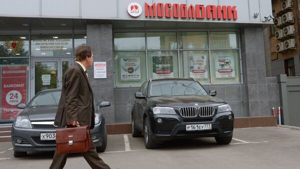 Мужчина проходит мимо головного офиса Мособлбанка. Архивное фото Мужчина проходит мимо головного офиса Мособлбанка. Архивное фото