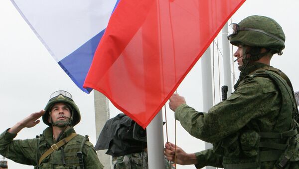 Солдаты поднимают российский флаг в полевом лагере Солдаты поднимают российский флаг в полевом лагере