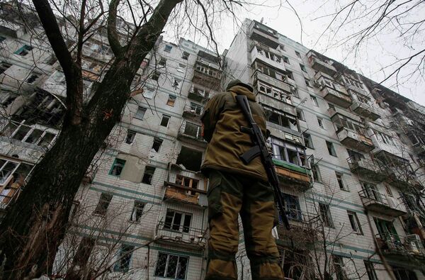 Боец ополчения возле поврежденного обстрелами дома в районе Донецкого аэропорта Боец ополчения возле поврежденного обстрелами дома в районе Донецкого аэропорта