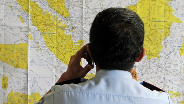 Сотрудник аэропорта смотрит на карту Индонезии в кризисном центре, созданном для поиска пропавшего рейса QZ8501 компании Air Asia Сотрудник аэропорта смотрит на карту Индонезии в кризисном центре, созданном для поиска пропавшего рейса QZ8501 компании Air Asia
