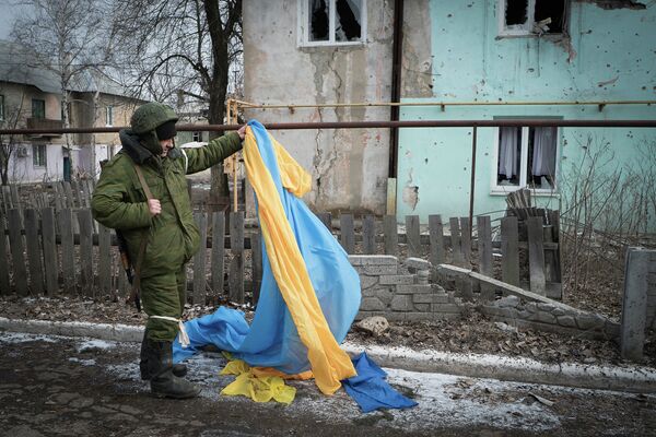 Ополченец держит флаг Украины, брошенный украинскими военными в Углегорске Ополченец держит флаг Украины, брошенный украинскими военными в Углегорске