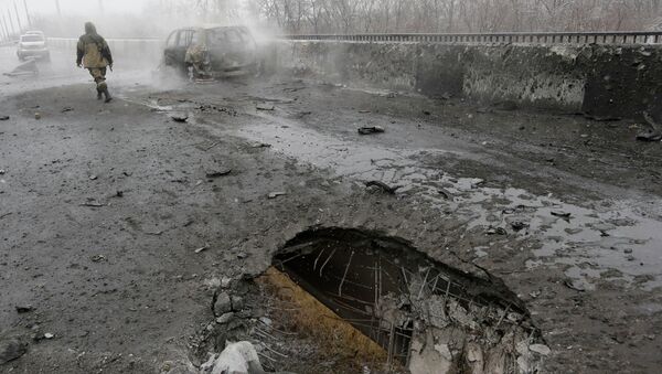Место попадания снаряда и сгоревший автомобиль в Донецке после обстрела украинскими силовиками Место попадания снаряда и сгоревший автомобиль в Донецке после обстрела украинскими силовиками