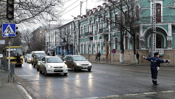 Сотрудник дорожно-постовой службы регулирует движение на одной из улиц Симферополя. Архивное фото Сотрудник дорожно-постовой службы регулирует движение на одной из улиц Симферополя. Архивное фото