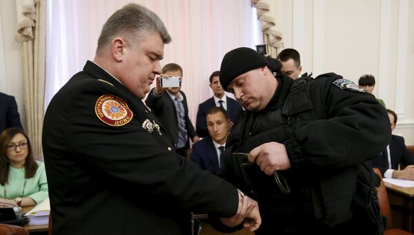 Полицейский надевает наручники на главу ГСЧС Украины Сергея Бочковского. Архивное фото Полицейский надевает наручники на главу ГСЧС Украины Сергея Бочковского. Архивное фото