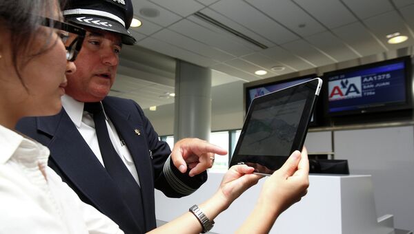 Пилот American Airlines смотрит траекторию полета на ipad. Архивное фото Пилот American Airlines смотрит траекторию полета на ipad. Архивное фото