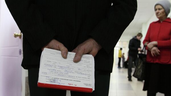 Пожилой мужчина держит в руках медицинскую карточку в одной из поликлиник города Омска Пожилой мужчина держит в руках медицинскую карточку в одной из поликлиник города Омска