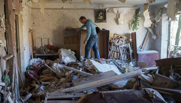 Жители Горловки в разрушенной квартире многоквартирного жилого дома на улице Кирова. Архивное фото Жители Горловки в разрушенной квартире многоквартирного жилого дома на улице Кирова. Архивное фото