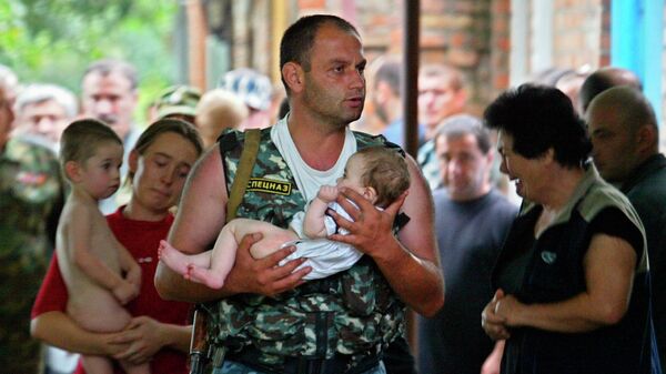 Боец спецназа несет спасенного ребенка во время штурма захваченной боевиками школы в Беслане. 2004 год Боец спецназа несет спасенного ребенка во время штурма захваченной боевиками школы в Беслане. 2004 год