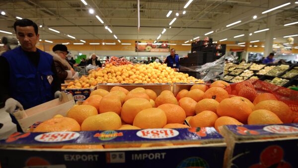 Продавец у прилавка с мандаринами из Турции в торговом зале гипермаркета Глобус. Архивное фото Продавец у прилавка с мандаринами из Турции в торговом зале гипермаркета Глобус. Архивное фото