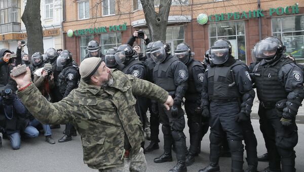 Украинский радикал бросает камень в офис Сбербанка в Киеве. 20 февраля 2016 Украинский радикал бросает камень в офис Сбербанка в Киеве. 20 февраля 2016