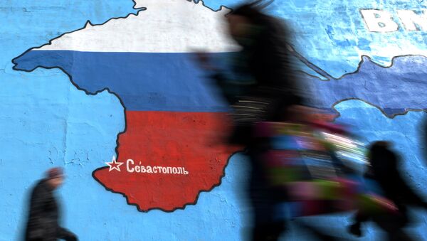 Прохожие у нарисованной на стене карты Крыма в цветах российского флага в Москве Прохожие у нарисованной на стене карты Крыма в цветах российского флага в Москве