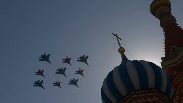Истребители Су-27 пилотажной группы Русские витязи и МиГ-29 пилотажной группы Стрижи пролетают над Красной площадью