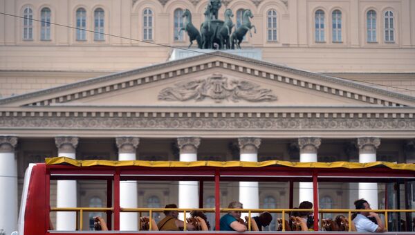 Туристы проезжают на экскурсионном автобусе мимо Большого театра в Москве. Архивное фото Туристы проезжают на экскурсионном автобусе мимо Большого театра в Москве. Архивное фото
