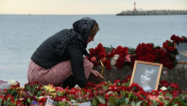 Женщина зажигает свечу в память о жертвах крушения самолета ТУ-154 в Сочи. Архивное фото Женщина зажигает свечу в память о жертвах крушения самолета ТУ-154 в Сочи. Архивное фото