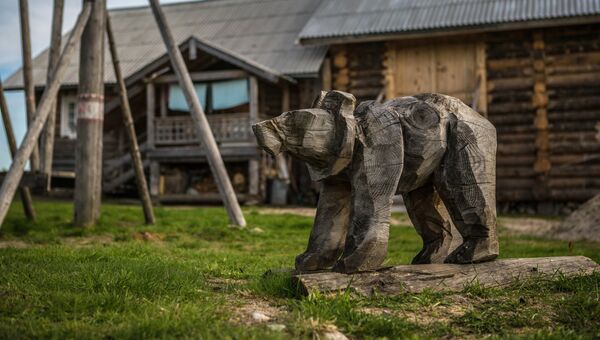 Деревянная фигура медведя на детской площадке в деревне Кинерма в Карелии Деревянная фигура медведя на детской площадке в деревне Кинерма в Карелии