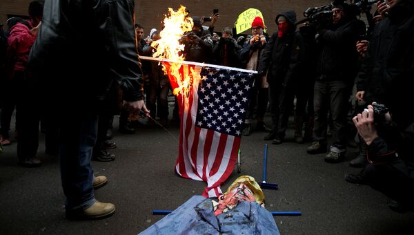 В Монреале протестующие против президентства Трампа сожгли флаг США. 20 января 2017 год В Монреале протестующие против президентства Трампа сожгли флаг США. 20 января 2017 год