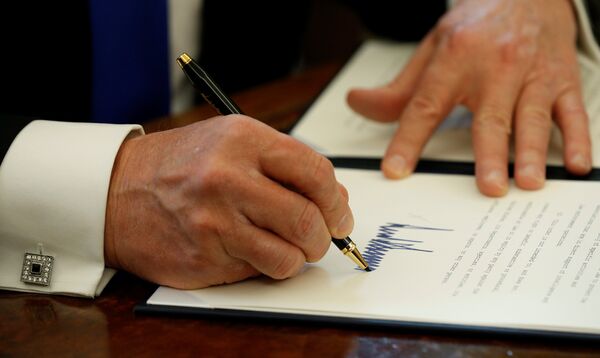 Президент США Дональд Трамп во время подписания документов. 24 января 2017 года Президент США Дональд Трамп во время подписания документов. 24 января 2017 года