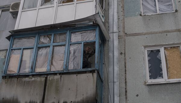 Мужчина заделывает балкон пленкой в Киевском районе Донецка Мужчина заделывает балкон пленкой в Киевском районе Донецка