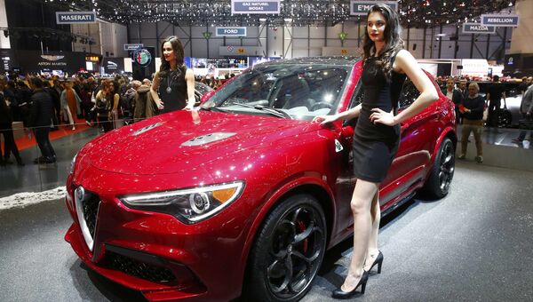 Модели позируют возле автомобиля Alfa Romeo Stelvio на Женевском международном автосалоне Модели позируют возле автомобиля Alfa Romeo Stelvio на Женевском международном автосалоне