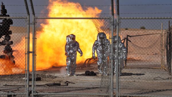 Люди в защитных костюмах на газоперерабатывающем заводе Хиян в сирийской провинции Хомс, 9 марта 2017 Люди в защитных костюмах на газоперерабатывающем заводе Хиян в сирийской провинции Хомс, 9 марта 2017