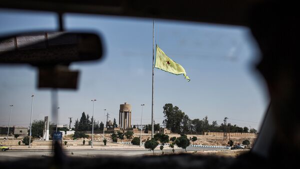 Флаг сил самообороны сирийских курдов (YPG) в провинции Ракка недалеко от границы с Турцией. Архивное фото Флаг сил самообороны сирийских курдов (YPG) в провинции Ракка недалеко от границы с Турцией. Архивное фото