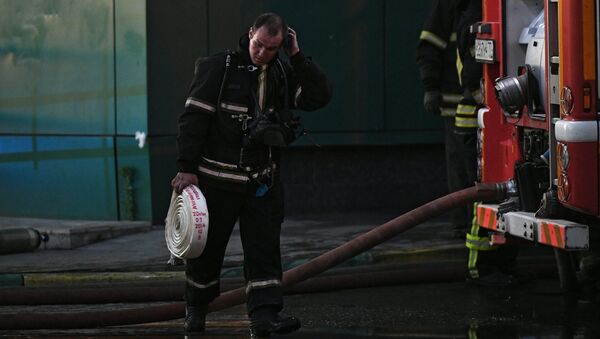Сотрудник противопожарной службы во время тушения пожара в здании торгового центра РИО на Дмитровском шоссе в Москве Сотрудник противопожарной службы во время тушения пожара в здании торгового центра РИО на Дмитровском шоссе в Москве