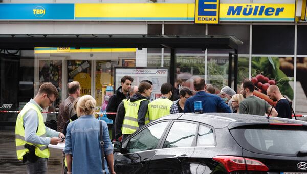 Полицейские возле супермаркета в Гамбурге, где мигрант напал с ножом. 28 июля 2017 Полицейские возле супермаркета в Гамбурге, где мигрант напал с ножом. 28 июля 2017