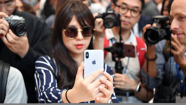 Девушка тестирует новый iPhone X в штаб-квартире Apple в Купертино Девушка тестирует новый iPhone X в штаб-квартире Apple в Купертино