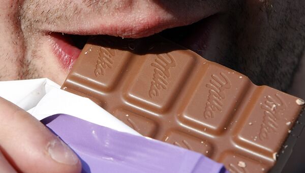 Мужчина ест шоколад Milka Мужчина ест шоколад Milka