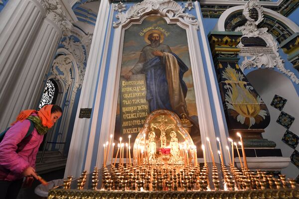 Прихожанка ставит поминальную свечку в Воскресенском соборе на территории Ново-Иерусалимского мужского монастыря Прихожанка ставит поминальную свечку в Воскресенском соборе на территории Ново-Иерусалимского мужского монастыря