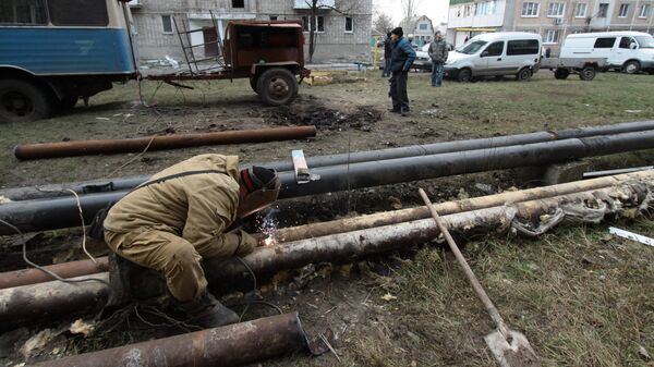 Сотрудник ЖКХ ремонтирует трубы жилого дома в городе Ясиноватая, пострадавшего в результате обстрела. 21 декабря 2017 Сотрудник ЖКХ ремонтирует трубы жилого дома в городе Ясиноватая, пострадавшего в результате обстрела. 21 декабря 2017
