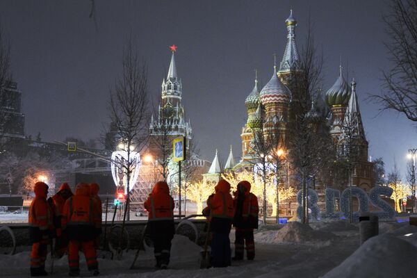 Сотрудники коммунальных служб убирают снег на улице в Москве Сотрудники коммунальных служб убирают снег на улице в Москве
