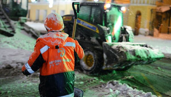 Сотрудники коммунальных служб убирают снег на улице в Москве. 31 января 2018 Сотрудники коммунальных служб убирают снег на улице в Москве. 31 января 2018