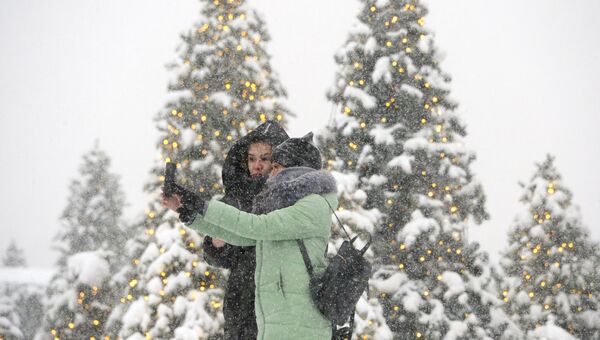 Девушки фотографируются во время снегопада на Манежной площади в Москве. 4 февраля 2018 Девушки фотографируются во время снегопада на Манежной площади в Москве. 4 февраля 2018