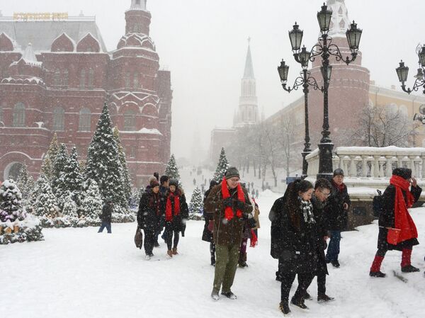 Прохожие во время снегопада на Манежной площади в Москве. Архивное фото Прохожие во время снегопада на Манежной площади в Москве. Архивное фото