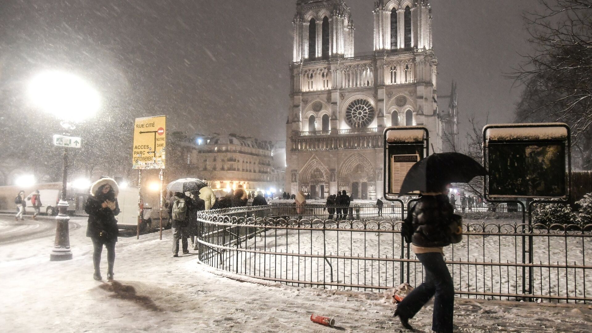 Прохожие возле собора Парижской Богоматери (Notre-Dame de Paris) во время снегопада в Париже Прохожие возле собора Парижской Богоматери (Notre-Dame de Paris) во время снегопада в Париже - РИА Новости, 1920, 27.12.2020