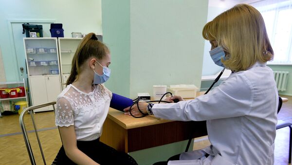 Врач осматривает пациента в целях профилактики заболевания гриппом и ОРВИ Врач осматривает пациента в целях профилактики заболевания гриппом и ОРВИ
