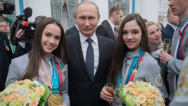 Президент РФ Владимир Путин и призеры женского фигурного катания XXIII зимних Олимпийских игр в Пхенчхане Алина Загитова (слева) и Евгения Медведева после церемонии вручения государственных наград спортсменам в Кремле