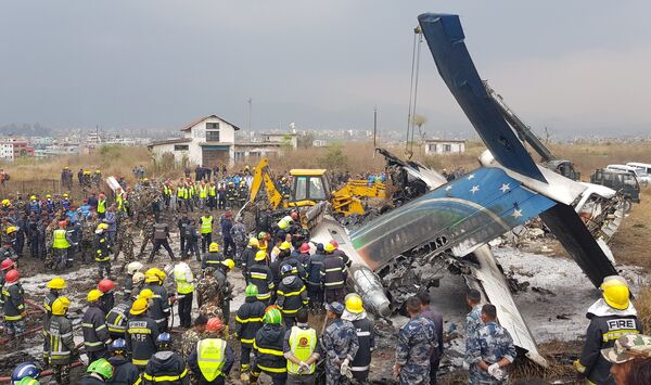 Спасатели на месте крушения самолета авиакомпании US-Bangla Airlines в Катманду, Непал. 12 марта 2018 Спасатели на месте крушения самолета авиакомпании US-Bangla Airlines в Катманду, Непал. 12 марта 2018