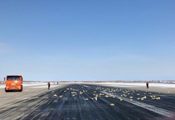 Взлетно-посадочная полоса аэропорта «Якутск» с рассыпанным грузом из самолёта Ан-12. 15 марта 2018 Взлетно-посадочная полоса аэропорта «Якутск» с рассыпанным грузом из самолёта Ан-12. 15 марта 2018