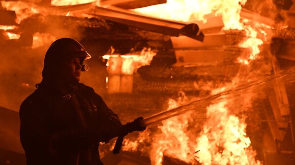 Сотрудник МЧС во время тушения пожара Сотрудник МЧС во время тушения пожара