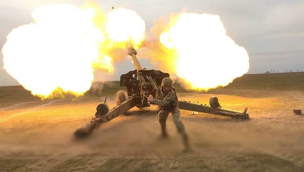 Украинский военный во время залпа из орудия Украинский военный во время залпа из орудия