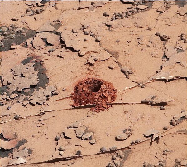 Первая лунка, вырытая починенным буром Curiosity в камне Дулут Первая лунка, вырытая починенным буром Curiosity в камне Дулут