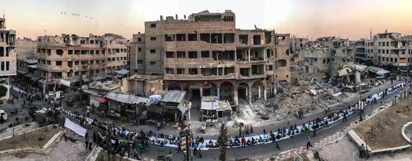 Работа фотографа Mohammed Badra из Сирии Iftar Amongst the Ruins, занявшая первое место в категории Новости и события в фотоконкурсе 2018 iPhone Photography Awards Работа фотографа Mohammed Badra из Сирии Iftar Amongst the Ruins, занявшая первое место в категории Новости и события в фотоконкурсе 2018 iPhone Photography Awards