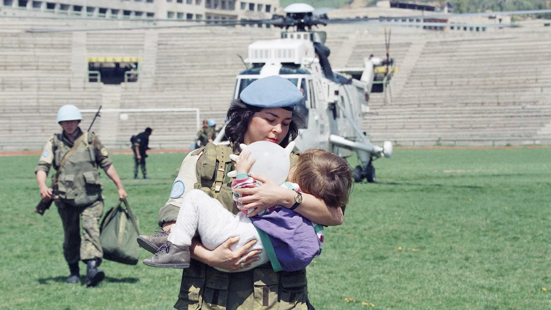 Женщина-солдат ООН несет двухлетнюю девочку, которую эвакуировали из города Горажде в Сараево, 25 апреля 1994 года - РИА Новости, 1920, 22.01.2020