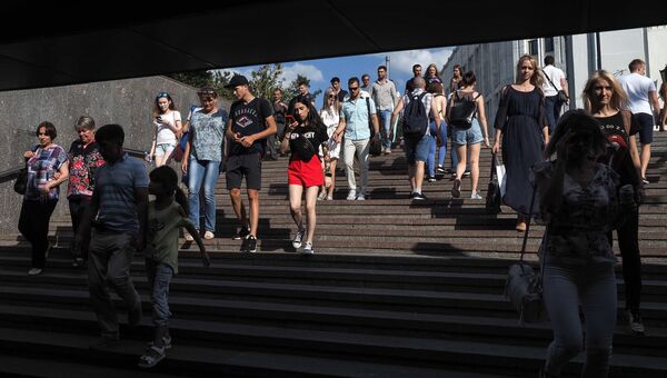 Прохожие в пешеходном переходе на площади Арбатские ворота в Москве. Архивное фото Прохожие в пешеходном переходе на площади Арбатские ворота в Москве. Архивное фото