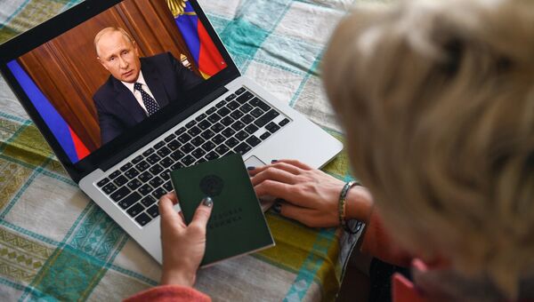 Жительница Новосибирска смотрит трансляцию обращения президента РФ Владимира Путина к гражданам России Жительница Новосибирска смотрит трансляцию обращения президента РФ Владимира Путина к гражданам России