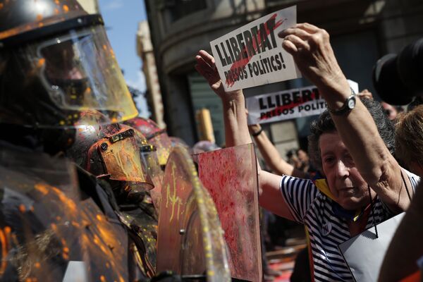 Женщина с плакатом Свободу политическим заключенным пред лицом полицейского на акции протеста в Барселоне. 29 сентября 2018 Женщина с плакатом Свободу политическим заключенным пред лицом полицейского на акции протеста в Барселоне. 29 сентября 2018